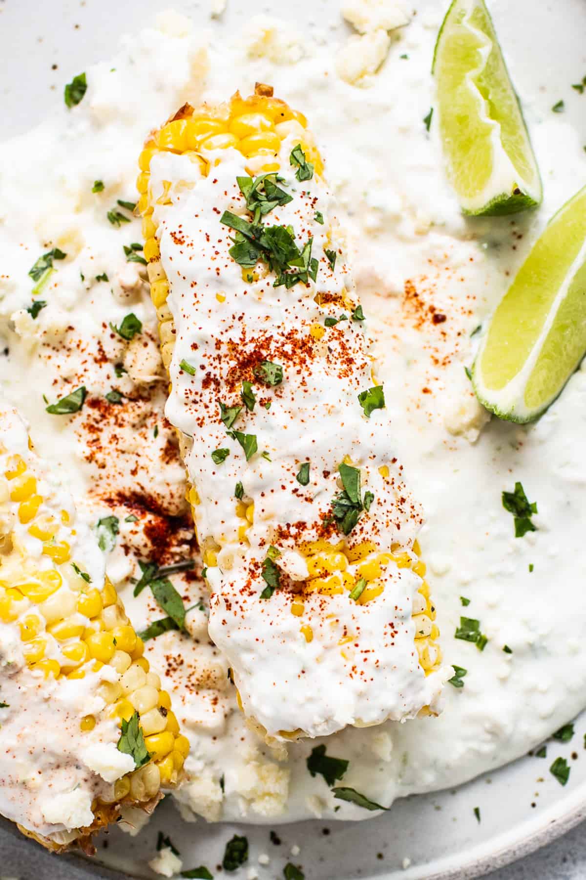 You're going to love this easy air fryer elote recipe! The fresh corn is seasoned and cooked to perfection, then rolled in a creamy spread full of cheesy and zesty Mexican flavors. Yum! Elote on a plate.
