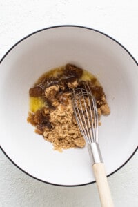 A bowl with a whisk and brown sugar in it.