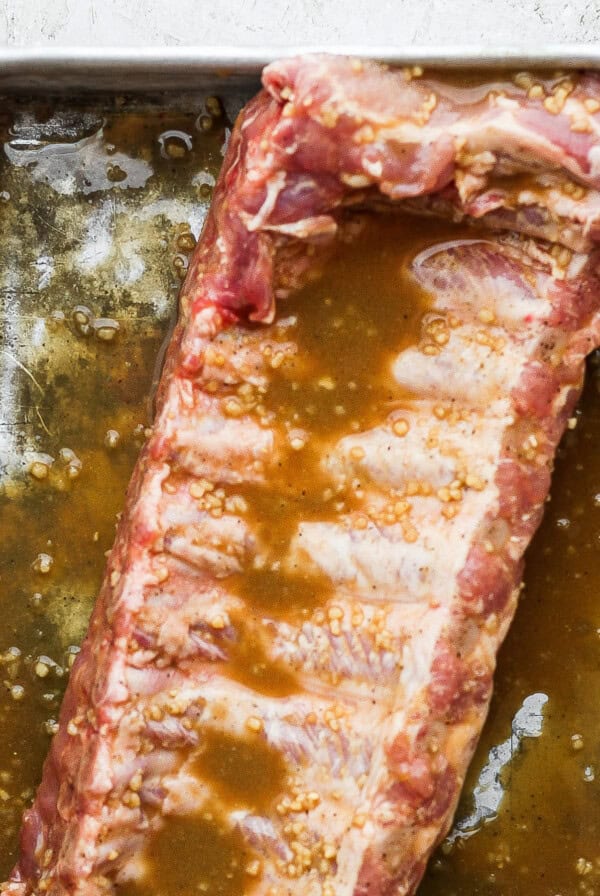 a piece of meat sitting on top of a pan covered in sauce.