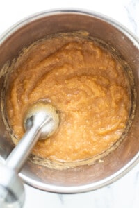A bowl of batter with a spoon in it.
