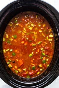 A crock pot full of soup and vegetables.