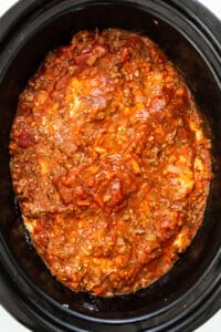 a crock pot filled with chili and meat.