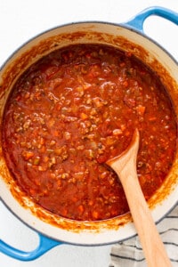 a pot of chili with a wooden spoon in it.
