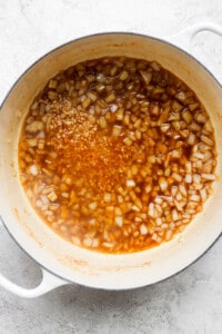 a pot of sauce with onions in it.