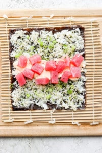 a piece of sushi on a wooden cutting board.