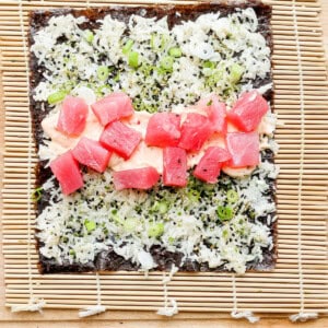a piece of sushi on a wooden cutting board.