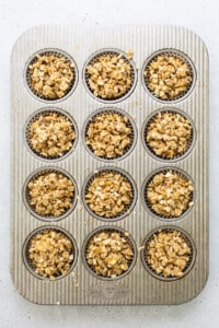 a muffin tin filled with granola muffins.