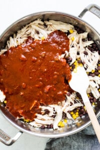 Mexican chicken in a skillet with sauce and corn.