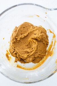 A bowl of pumpkin batter in a glass bowl.