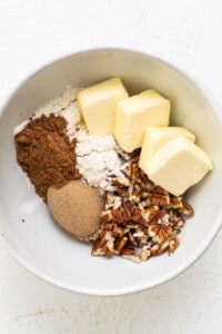 A bowl with butter, sugar, and pecans in it.