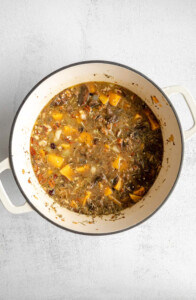 A pot of soup with vegetables and meat in it.