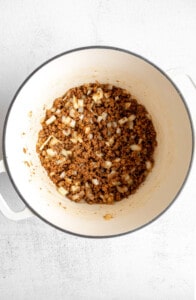 A white bowl filled with ground beef and onions.