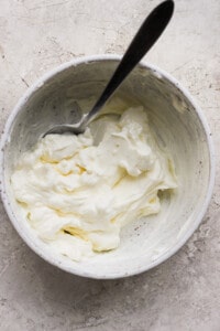 Whipped cream in a bowl with a spoon.