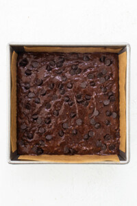 A brownie in a baking pan with chocolate chips.
