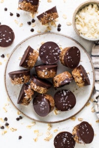 A plate topped with chocolate covered granola bars.