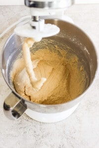 A bowl of dough being mixed in a mixer.