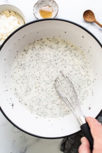 A person whisking chia seeds into a bowl.