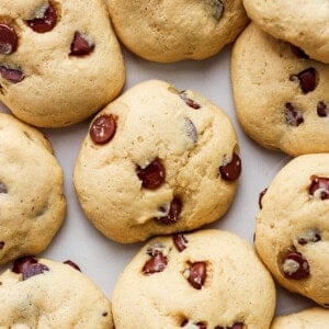 A group of chocolate chip cookies on a white surface.