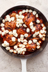 A pan with chicken and cheese in it.