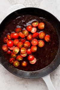 A frying pan with tomatoes in it.