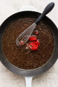 A frying pan with a red pepper in it.