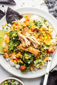 A white plate with chicken and vegetables on it.