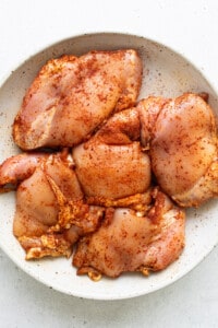 Chicken breasts in a white plate on a white background.