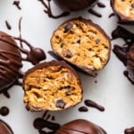 Chocolate covered peanut butter truffles on a white surface.