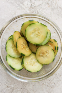 Sliced cucumbers in a glass bowl.