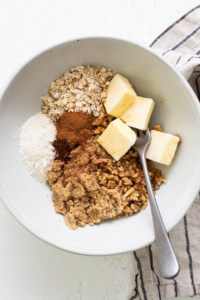 Oats, cinnamon, butter and sugar in a bowl.