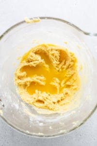 A glass bowl with a yellow batter in it.
