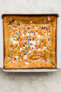 A cookie bar with sprinkles in a pan.