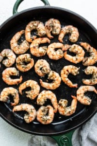 Grilled shrimp in a skillet with herbs.