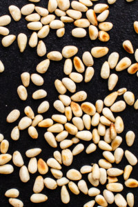 A close up of sesame seeds on a black surface.