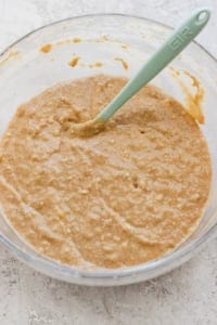 A bowl of thick, mixed batter with a green silicone spatula.