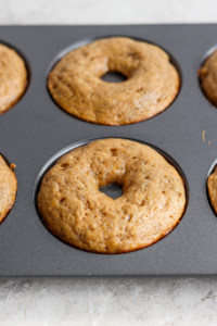 Freshly baked donuts in a non-stick baking pan.